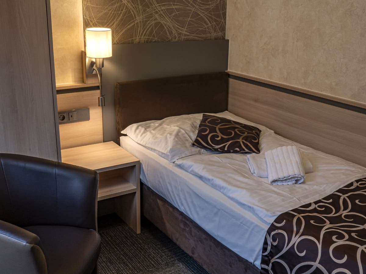 Einzelzimmer mit moderner Lampe und Schreibtisch