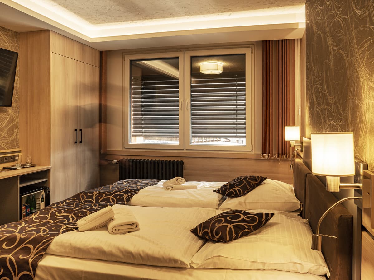 Rodinný pokoj se třemi lůžky a nočními lampičkami