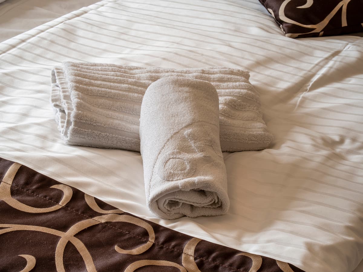 Close-up of towels prepared on the bed