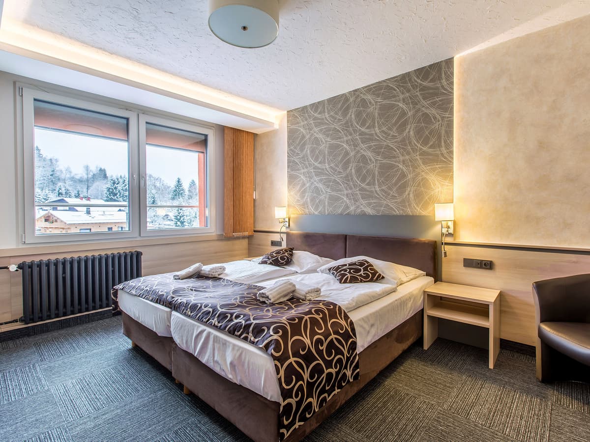 Doppelzimmer mit dekorativer Bettwäsche und Schreibtisch