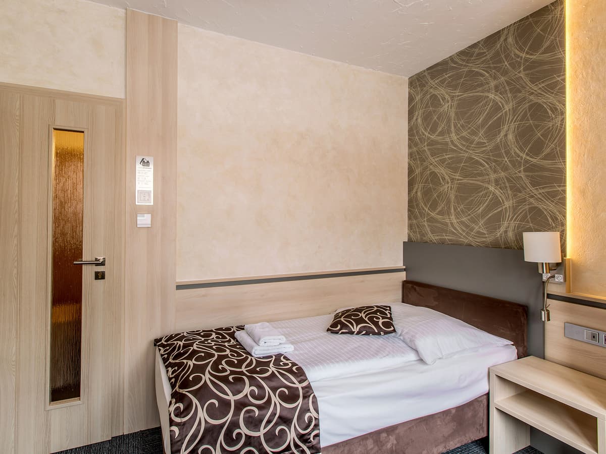 Einzelzimmer mit eleganter Tapete und Holzverkleidung