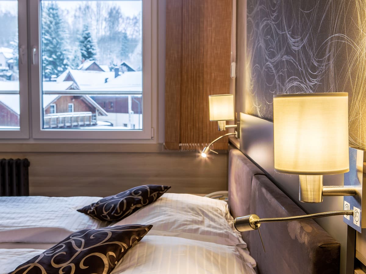 Blick auf Bett und Lampe am Fenster im Doppelzimmer