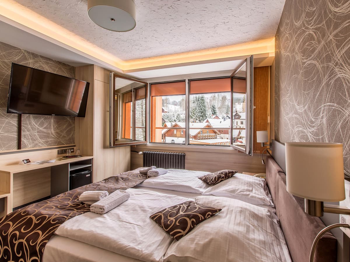 Gemütliches Zimmer mit Fernseher und zwei Betten