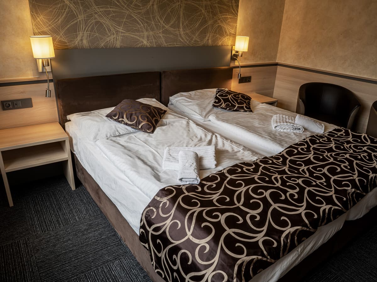 Komfortables Zimmer mit zwei Betten und Sesseln