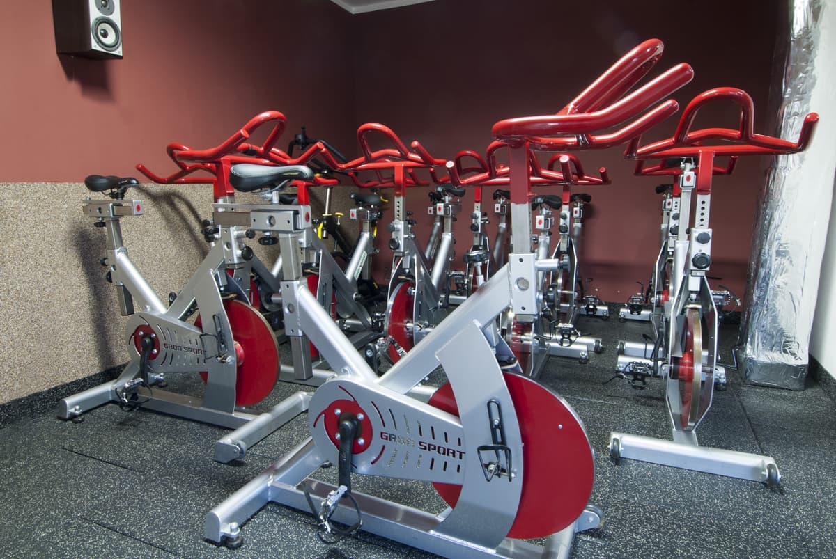 A row of stationary bikes in the gym, waiting to be used for cardio exercise.