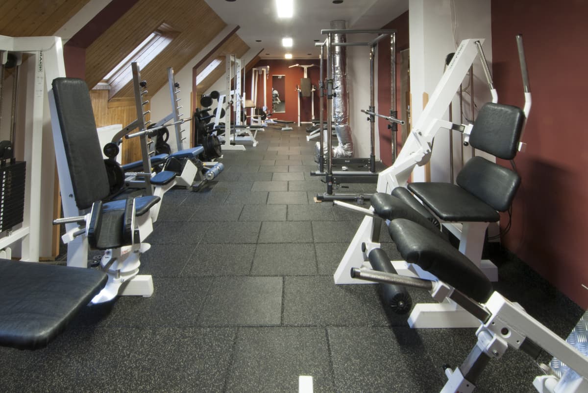 Posilovací stroje na ruce a nohy s modrými prvky na čalounění.