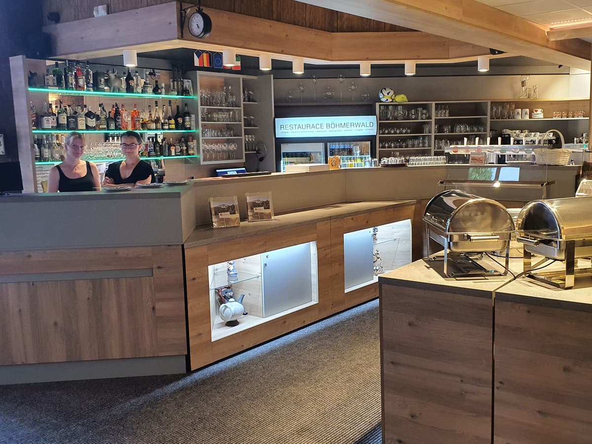 Teil des Restaurants mit einer modernen Theke und einer Vitrine mit Gerichten. Bar ist im Hintergrund.